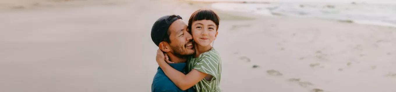 Dad carrying his daughter on the beach  