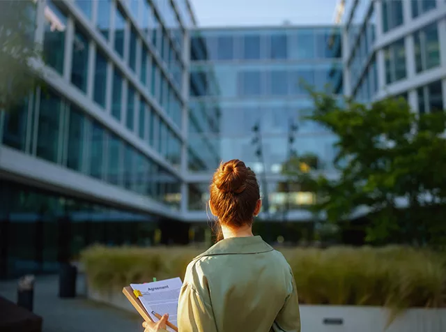 women in front of green building 