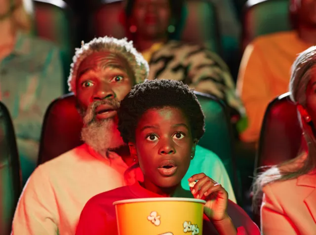 Gezin kijkt in spanning naar een film in de bioscoop