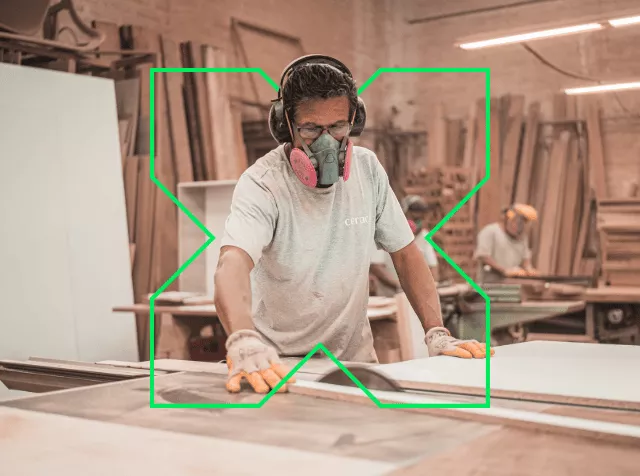 Homme en train de poncer du bois entouré d'un logo "X" Pluxee