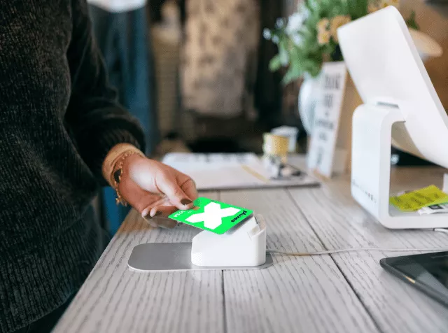Personne payant sur un terminal de paiement en sans contact avec sa carte multibenefits Pluxee