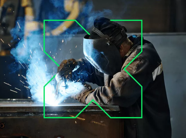 Homme en train de souder entouré d'un logo "X" Pluxee