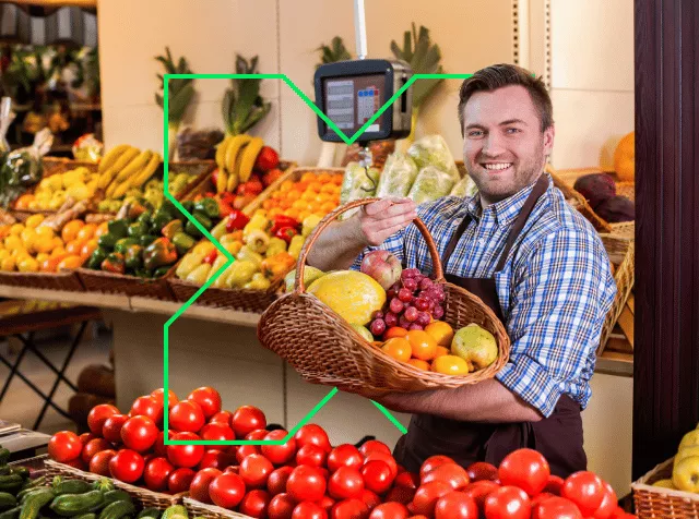 Commerçant de fruits et légumes tenant un panier de fruits dans ses mains