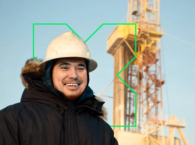 Homme portant un casque et une veste chaude sur un chantier de pétrole