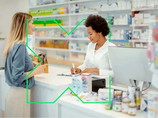 Pharmacienne derrière son comptoir servant une cliente