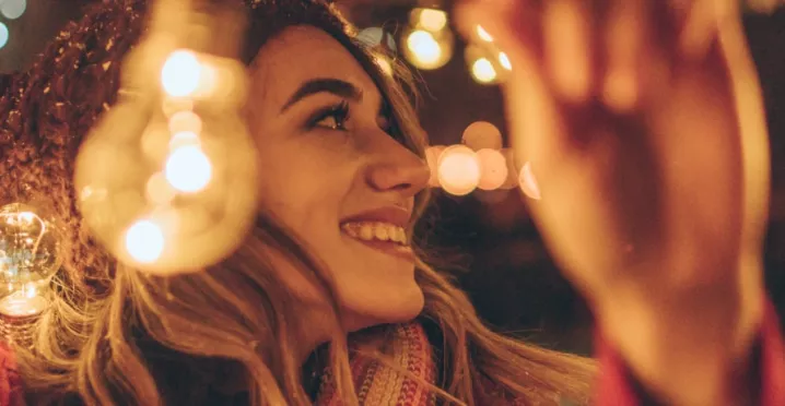Jeune fille accrochant des guirlandes de Noël