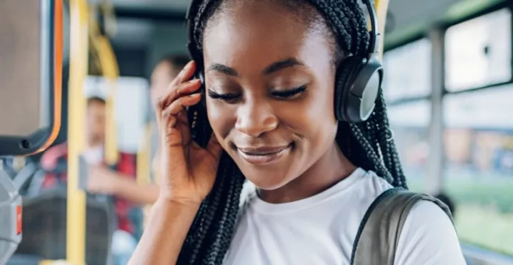 Personne portant un casque audio et un sac à dos lors d’un trajet en bus dans le cadre de la mobilité domicile-travail durable