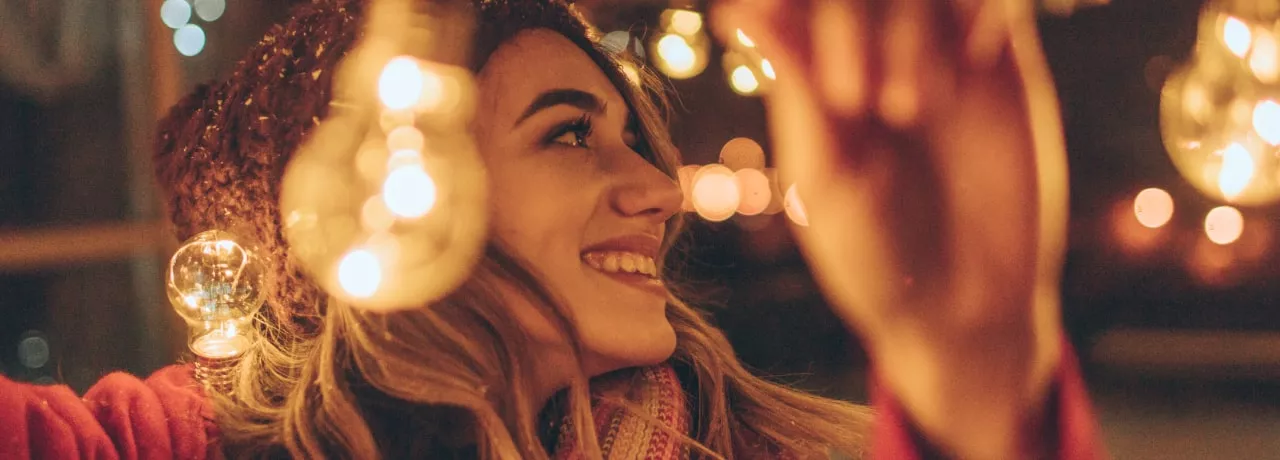 Jeune fille accrochant des guirlandes de Noël
