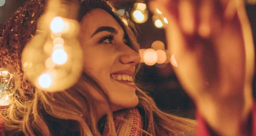 Jeune fille accrochant des guirlandes de Noël