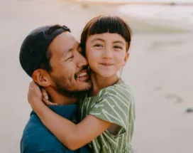 Dad carrying his daughter on the beach 