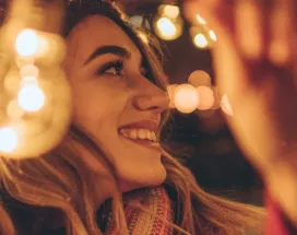 Jeune fille accrochant des guirlandes de Noël