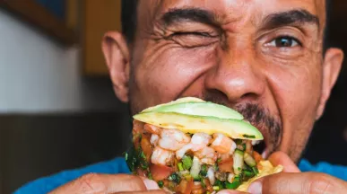 Homme mangeant un tacos aux crevettes