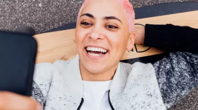 Jeune fille sur son skateboard regardant son smartphone