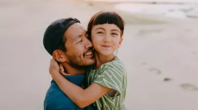 Dad carrying his daughter on the beach 