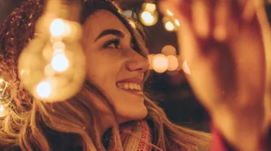 Jeune fille accrochant des guirlandes de Noël