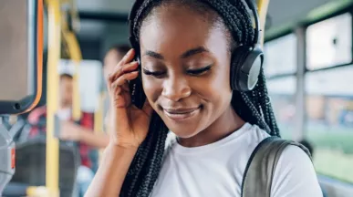 Personne portant un casque audio et un sac à dos lors d’un trajet en bus dans le cadre de la mobilité domicile-travail durable