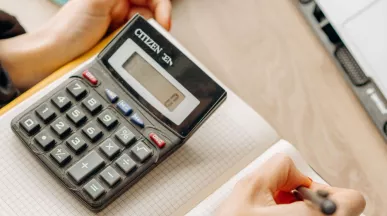 Calcul d’un budget avec une calculatrice et prise de notes dans un cahier.