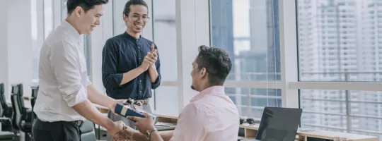 Un employé reçoit un cadeau de son équipe