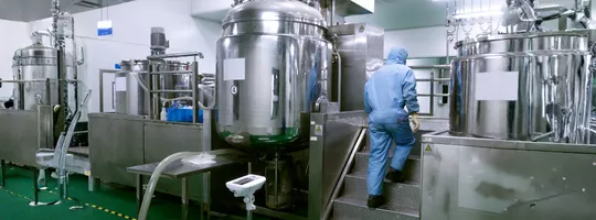 Usine chimique avec une personne portant une combinaison de protection